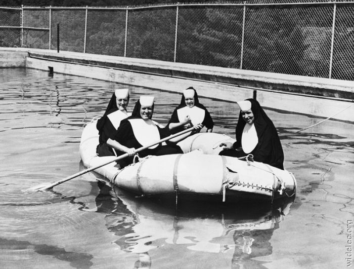 Nuns rowing a dinghy in a pool
